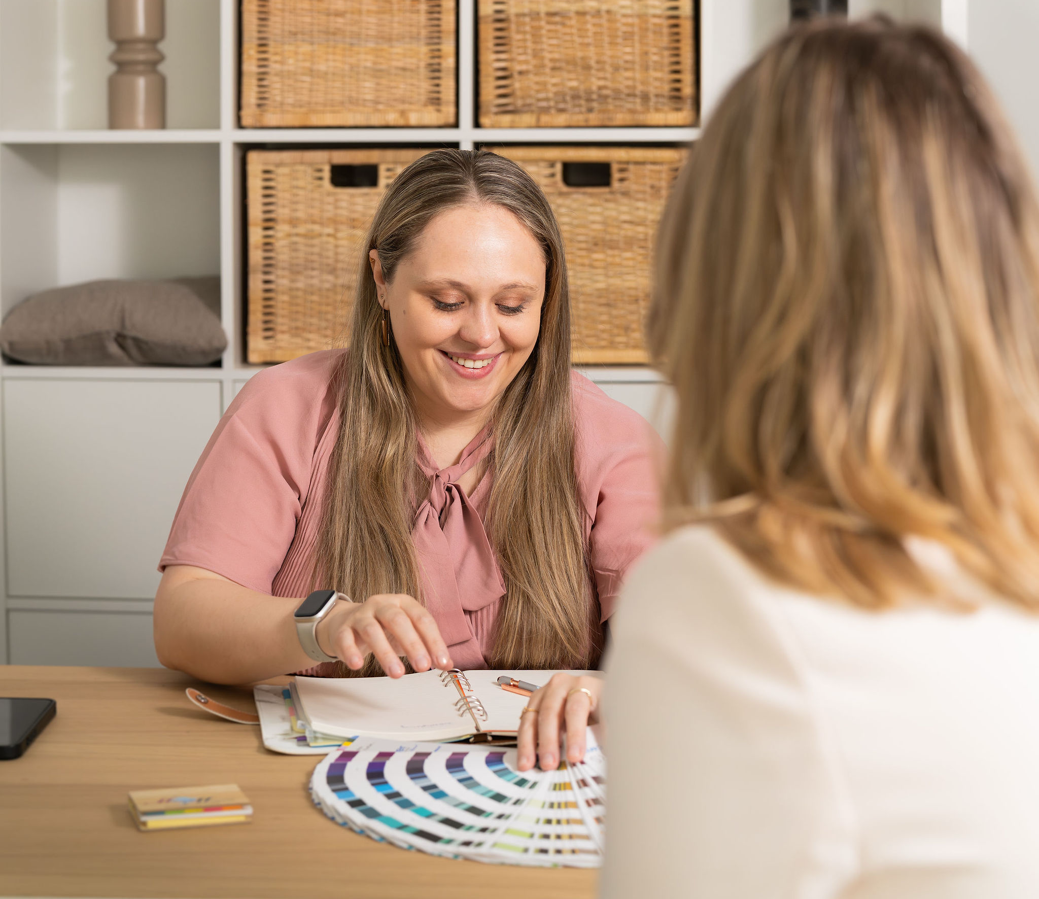Romana, Hochzeitsplanerin, lächelt im Gespräch mit Farbpalette