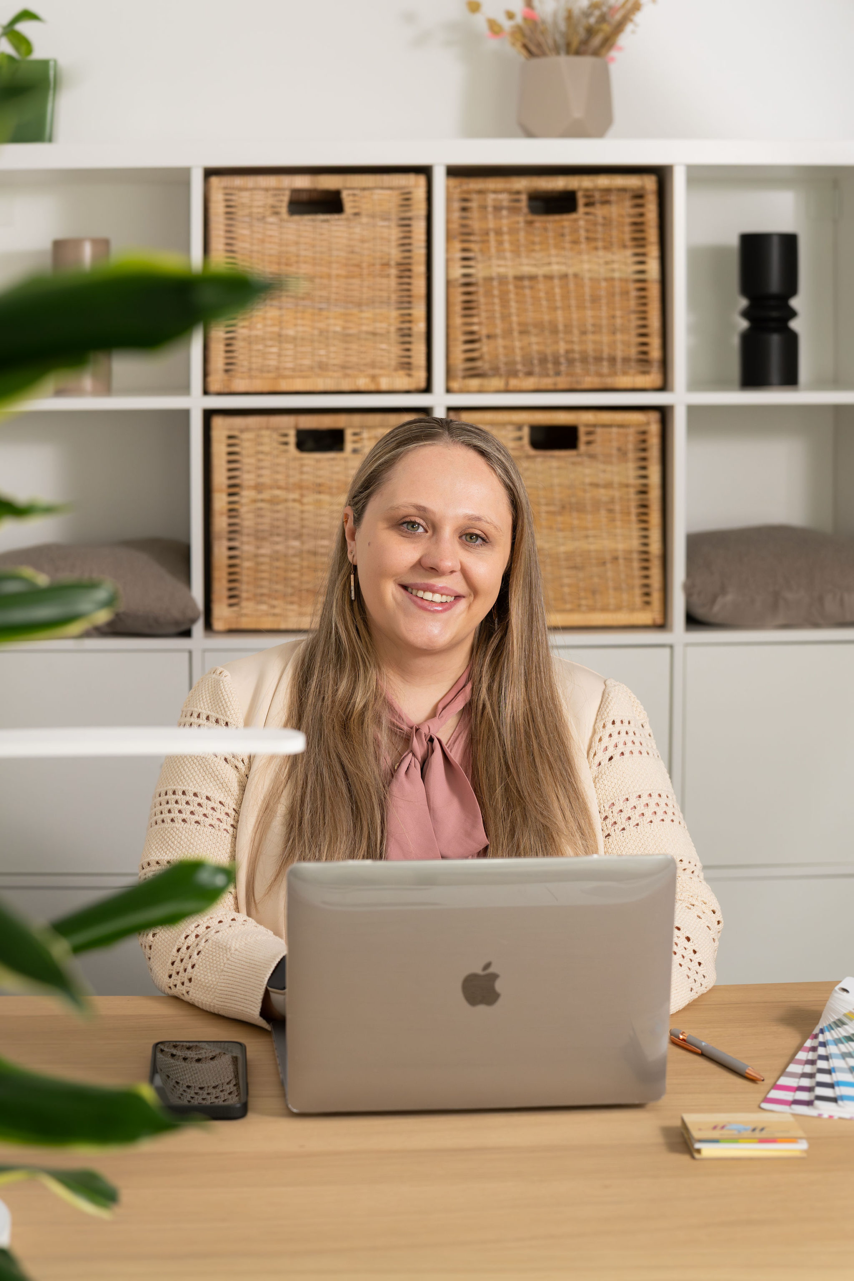 Romana, Hochzeitsplanerin, am Schreibtisch mit Laptop und Farbpalette